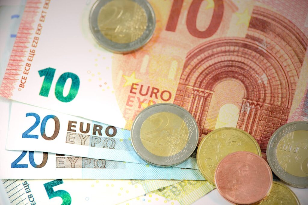 Detailed shot of Euro banknotes and coins showcasing currency denominations.