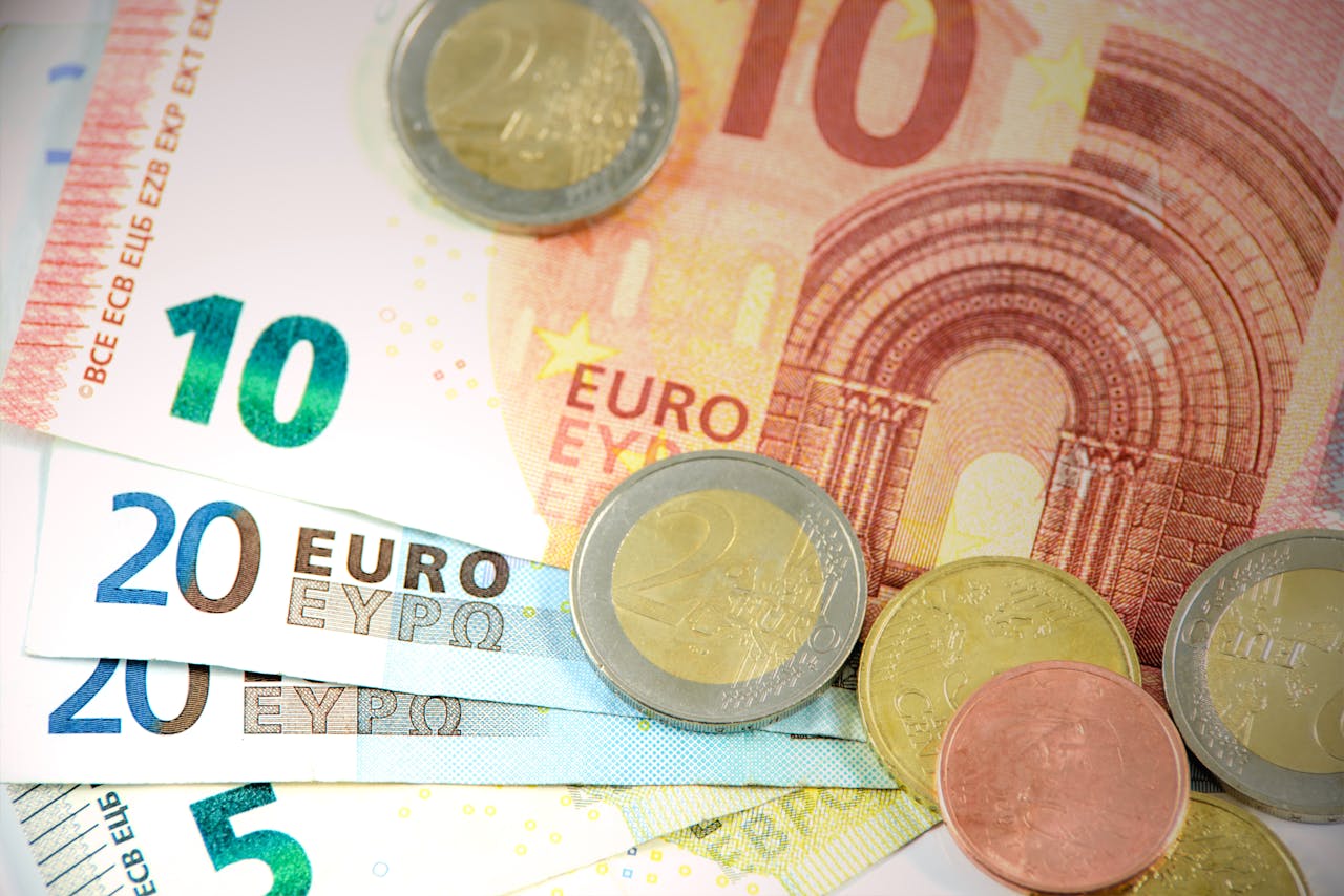 Detailed shot of Euro banknotes and coins showcasing currency denominations.